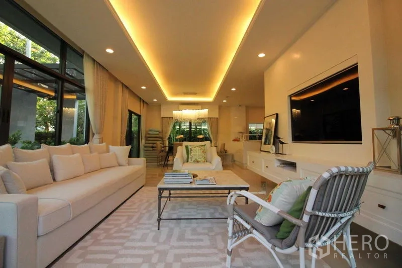 Detached House for rent in Prawet, Bangkok - Spacious living room with recessed ceiling lights and a wall-mounted TV.