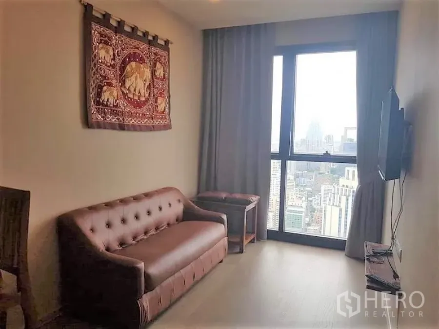公寓 出租在Watthana, Bangkok - 客厅设挂墙电视、沙发与落地窗城市景观。
