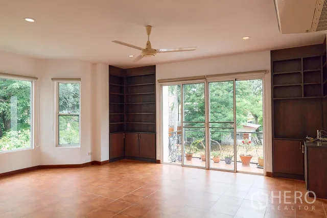 Detached House for rent in Watthana, Bangkok - Upper-level family room with built-in shelving and sliding doors to a balcony.