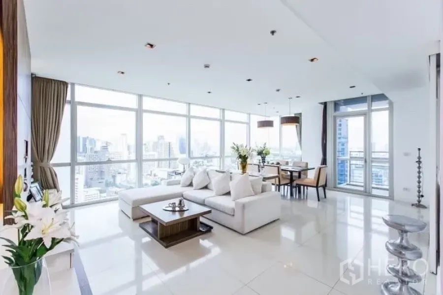 Condominium for rent in Pathum Wan, Bangkok - Bright open-plan living and dining room with floor-to-ceiling windows and Bangkok skyline views.