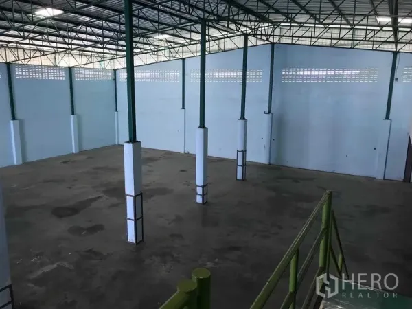 Warehouse for rent in Bang Phli, Samut Prakan - Elevated view of the open warehouse floor with green steel columns and ventilated high walls.
