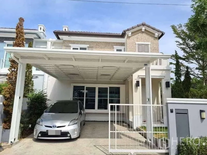 Detached House for rent in Prawet, Bangkok - Street-facing facade of the detached house with white carport and gate.