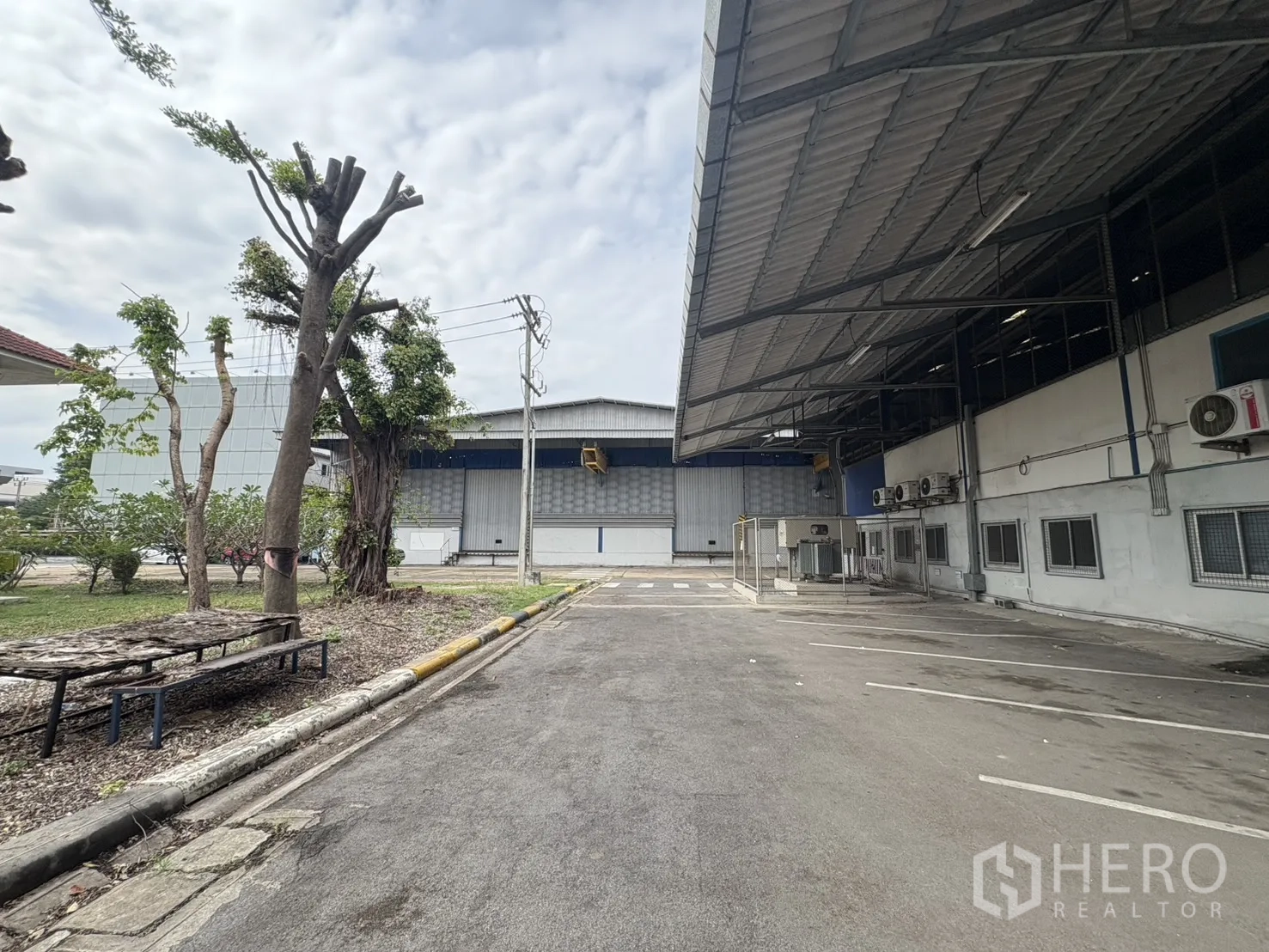 Factory for rent in Phra Pradaeng, Samut Prakan - Covered side lane beside the warehouse and landscaped verge.