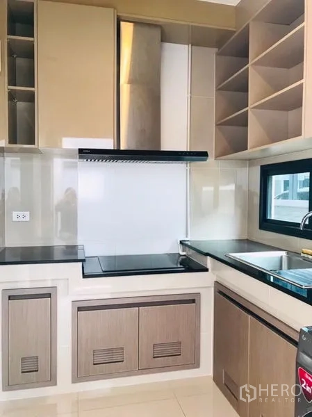 Detached House for rent or sale in Pathum Thani - Compact modern kitchen with cabinetry, stovetop and extractor hood.