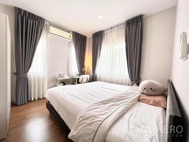 บ้าน ให้เช่าหรือขายในBang Khen, Bangkok - ห้องนอนมุมบ้าน ชุดเครื่องนอนสีขาว โต๊ะทำงาน เครื่องปรับอากาศ และหน้าต่างสองด้าน