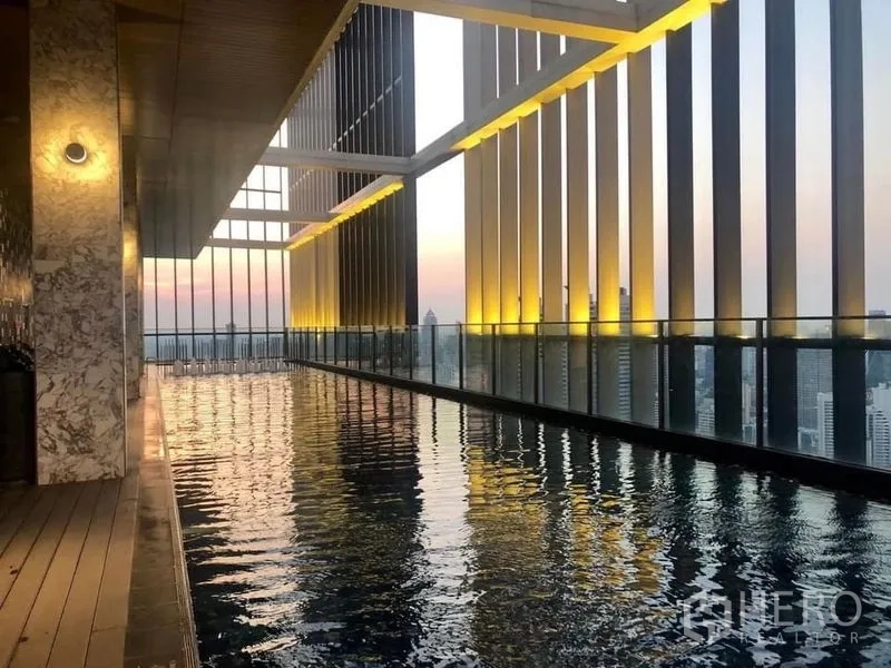 Condominium for rent in Khlong Toei, Bangkok - Covered sky pool with illuminated vertical fins and sweeping evening skyline views.