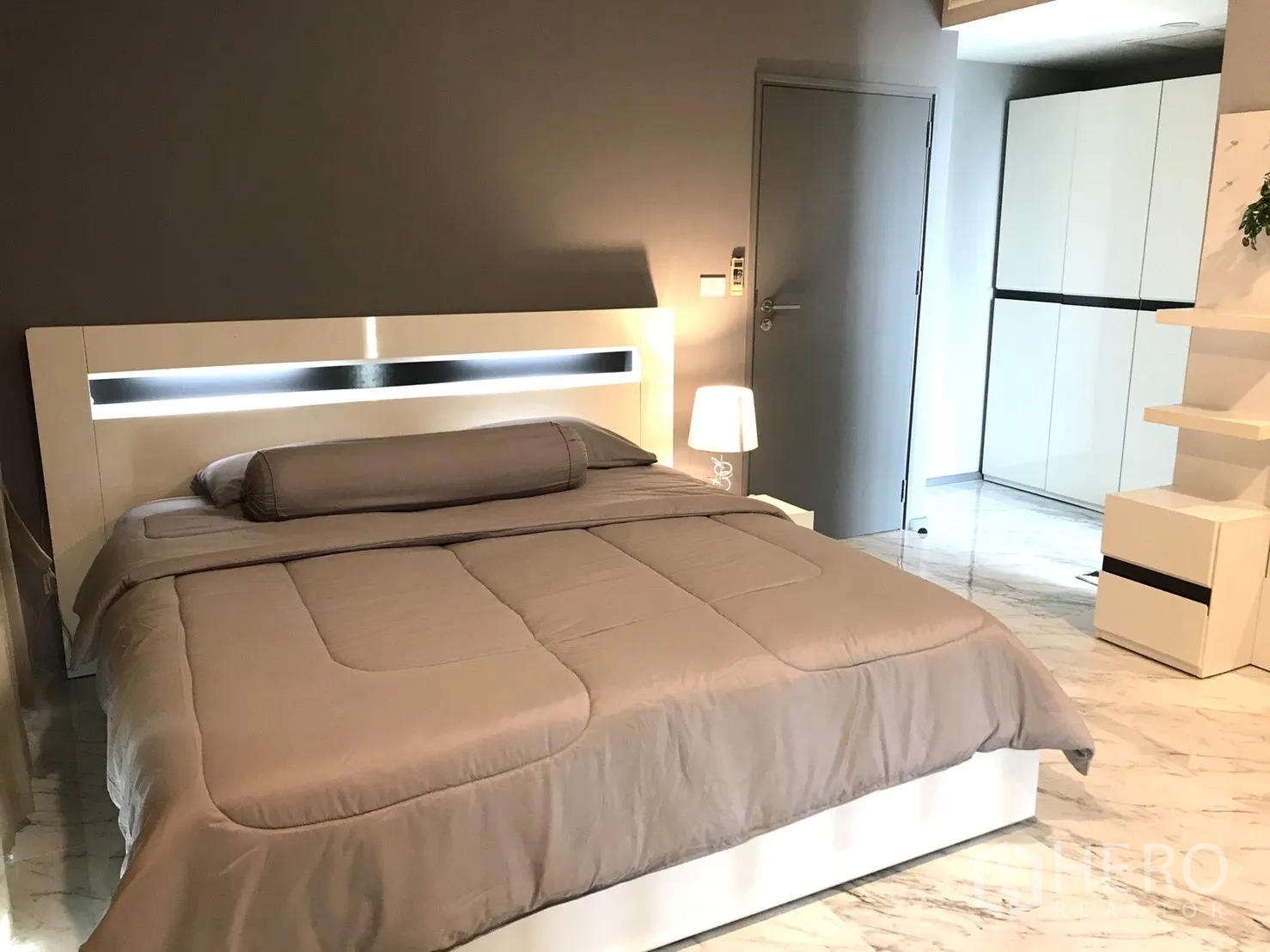 Condominium for rent in Khlong Toei, Bangkok - Bedroom featuring an illuminated headboard, bedside lamps and marble tiles.