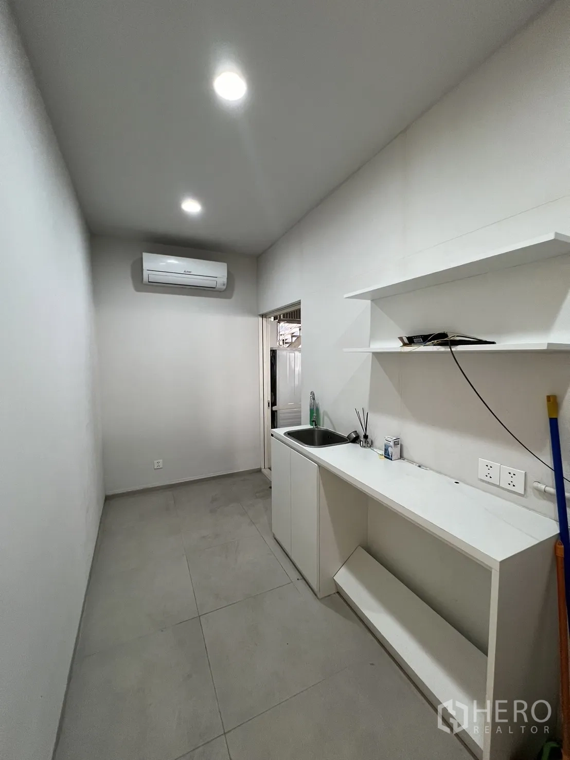 Retail Space for rent in Bangkok - Rear prep area with sink, shelving, air conditioner and recessed lighting