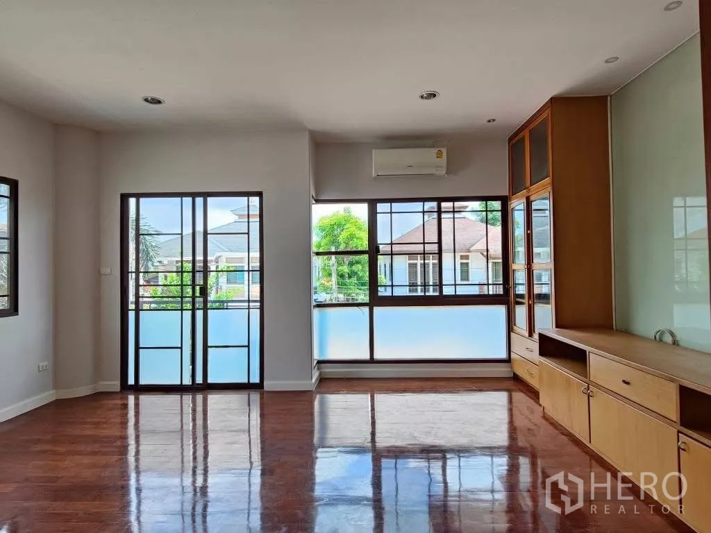 Detached House for rent or sale in Mueang Nonthaburi, Nonthaburi - Sunlit bedroom with balcony doors, air conditioner and full-height cabinets.