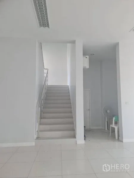 Factory for rent or sale in Lam Luk Ka, Pathum Thani - Bright ground-floor lobby with white tile floor and central staircase.