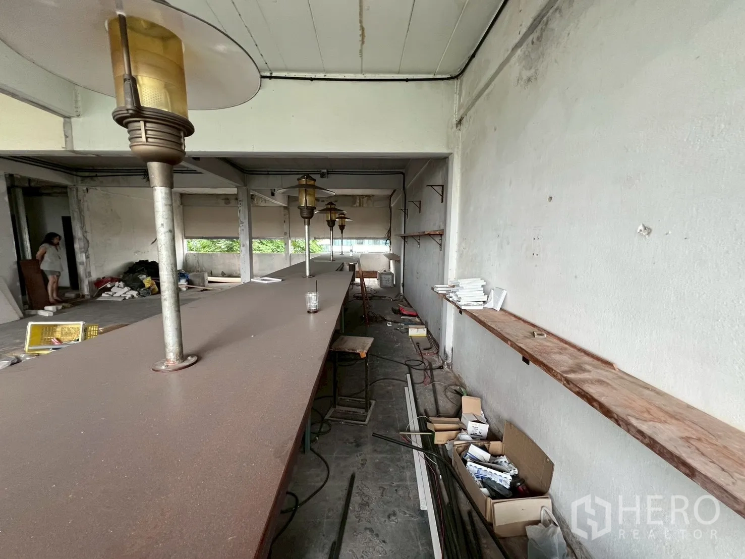 Retail Space for rent in Watthana, Bangkok - Long counter and wall-mounted shelves with boxes and cabling, showing utilities in place.