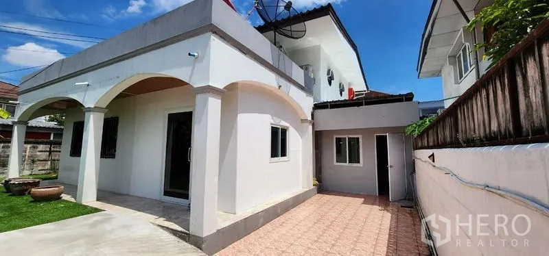 Detached House for rent in Lat Phrao, Bangkok - Side exterior with arched terrace and a wide paved parking area beside the house.