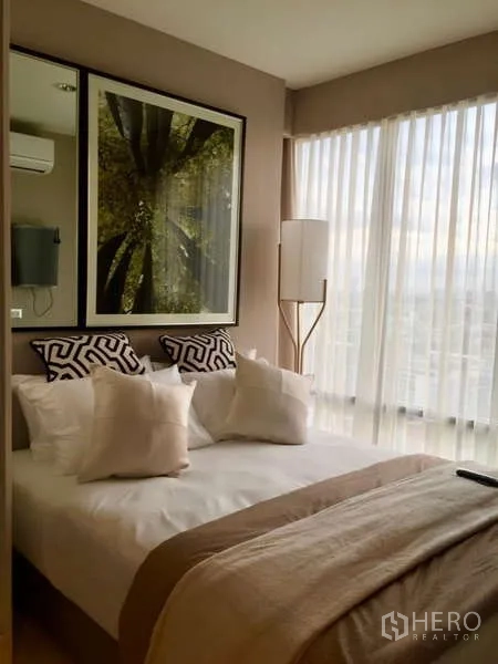 Condominium for rent in Khlong Toei, Bangkok - Second bedroom with large windows, sheer curtains and soft neutral palette.