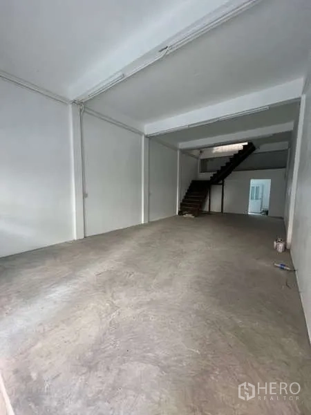 Shophouse for rent in Watthana, Bangkok - Deep retail area with white walls and exposed concrete flooring.