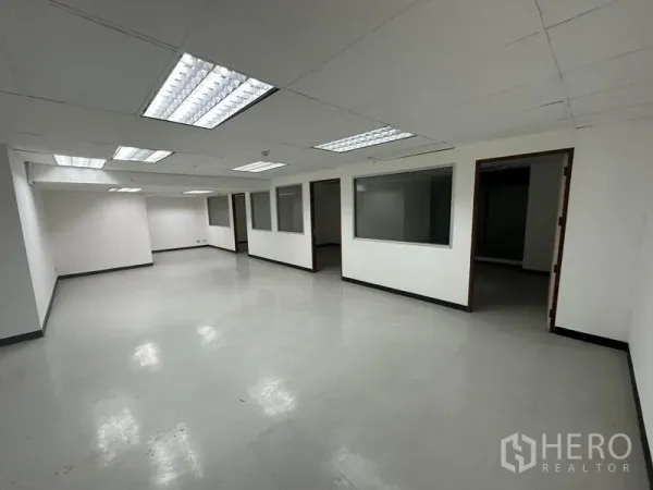 Office Space for rent in Khlong Toei, Bangkok - Open-plan Bangkok office with drop ceiling lights and glass-partitioned rooms.
