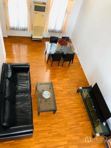 Townhouse for rent in Khlong Toei, Bangkok - Top-down view of the living room showing seating area, coffee table and bright wood flooring.