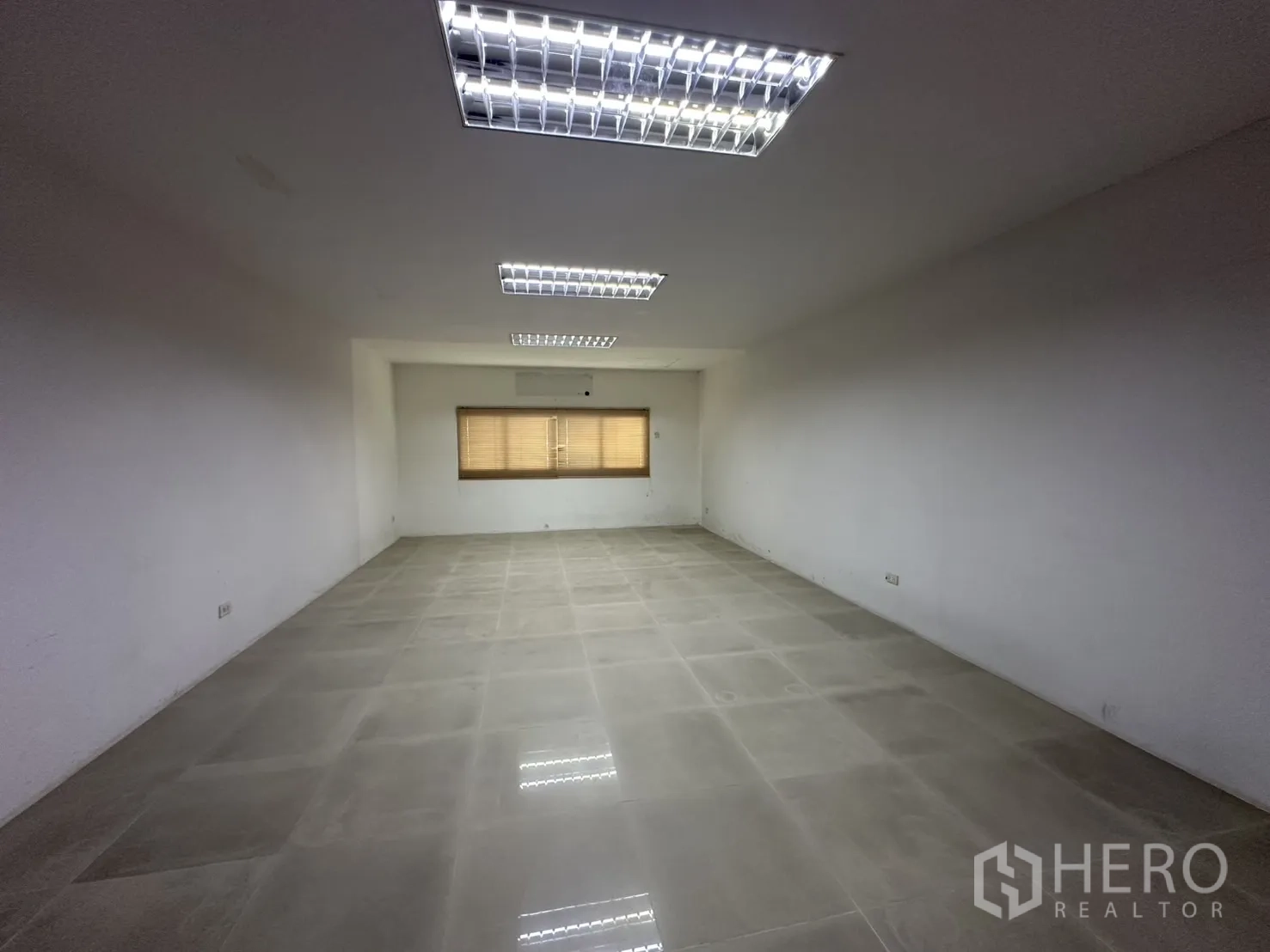 Factory for rent - Air-conditioned office space with three narrow windows and blinds.