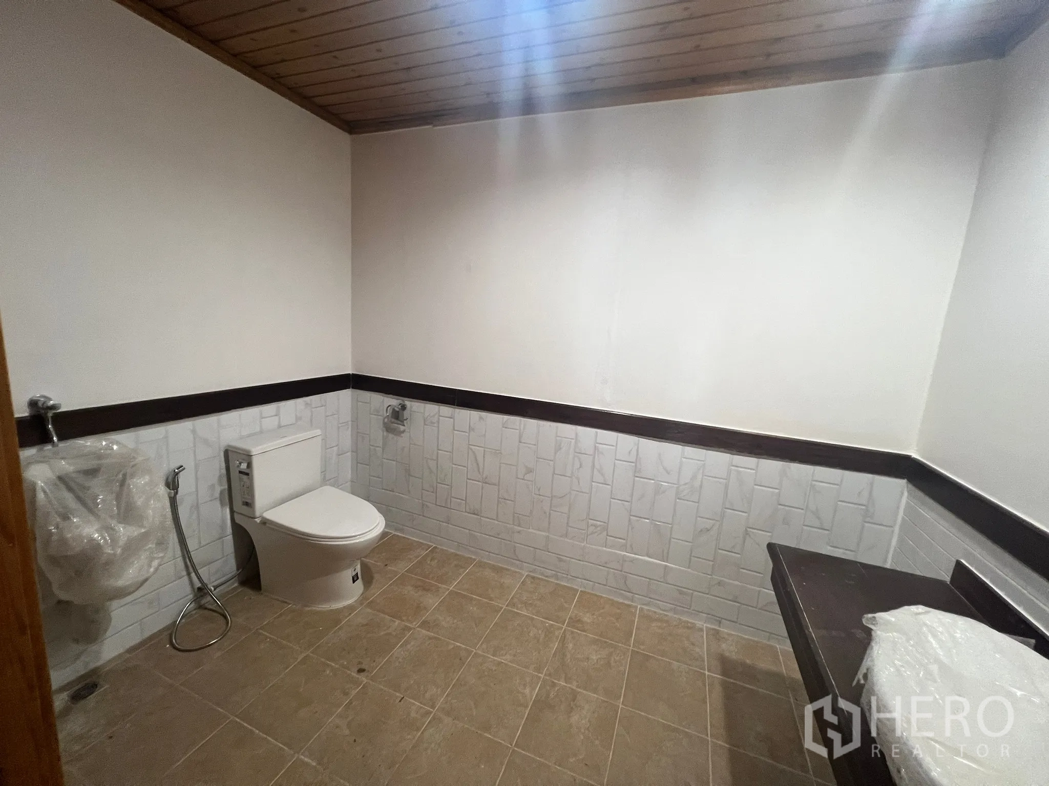 Home Office for rent in Suan Luang, Bangkok - Large restroom with toilet, urinal and tiled walls and floor.
