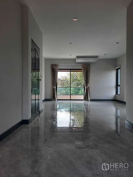 Home Office for rent in Huai Khwang, Bangkok - Bright live–work space with balcony doors, curtains and wall-mounted air conditioner.