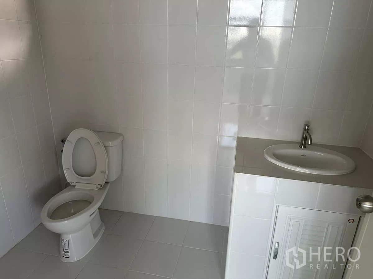 Warehouse for rent in Wang Noi, Phra Nakhon Si Ayutthaya - Clean tiled restroom with toilet and vanity inside the warehouse office.