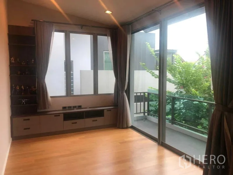 Detached House for rent or sale in Bang Kapi, Bangkok - Upper floor family room with large windows, built-in shelving and balcony access.
