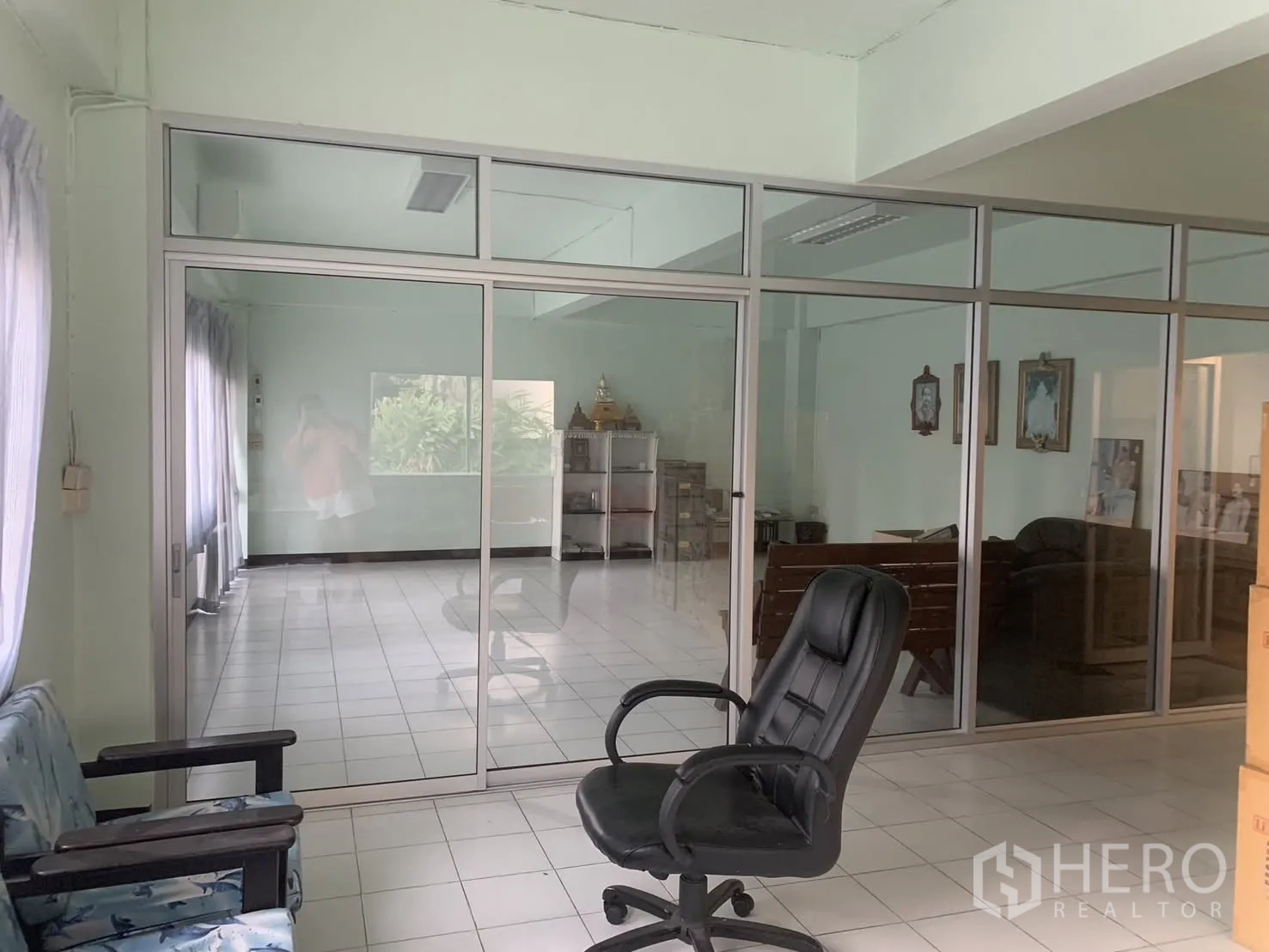 Warehouse for rent in Bang Phli, Samut Prakan - Glass-partitioned office area inside the warehouse with seating and tiled flooring.