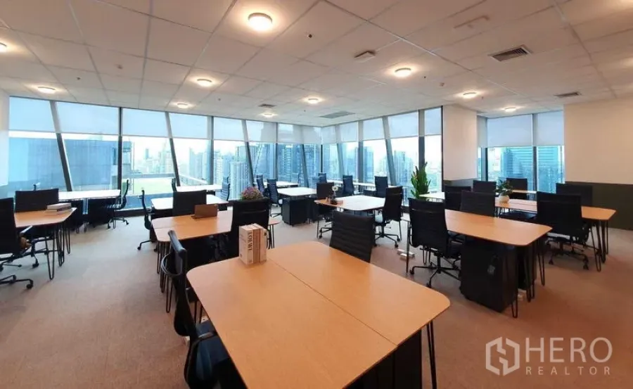 办公空间 出租 - G Tower 高楼层开放式办公室，落地窗俯瞰城市天际线，木质工位、黑色座椅与地毯地面。
