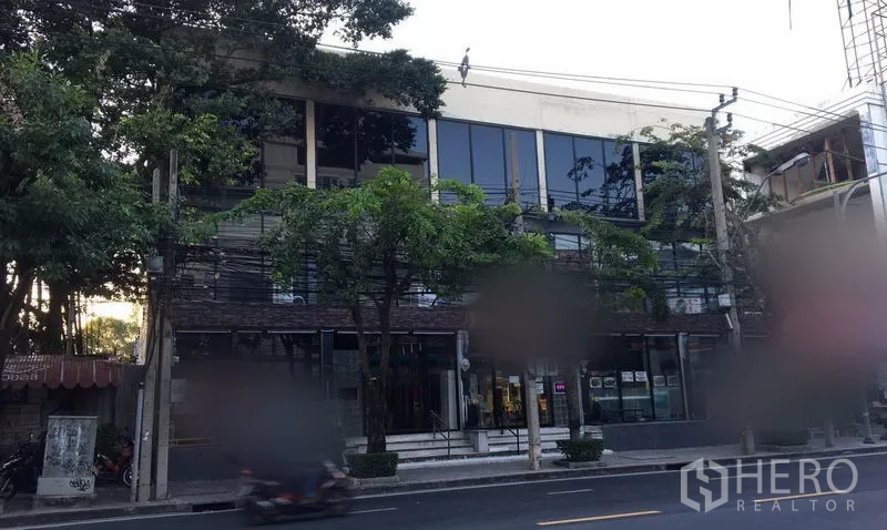 零售空间 出租在Watthana, Bangkok - 曼谷Ekkamai临街零售建筑，整面玻璃窗与树木遮荫。