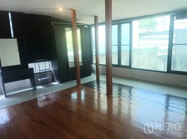 Detached House for rent in Khlong Toei, Bangkok - Bright room with floor-to-ceiling windows and polished wooden floor