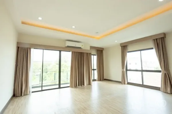 Home Office for rent in Bang Khen, Bangkok - Corner room with floor-to-ceiling windows, balcony access and wall-mounted air conditioner.