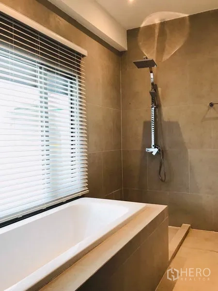 Townhouse for rent or sale in Khlong Toei, Bangkok - Family bathroom with bathtub, separate shower and window blinds.