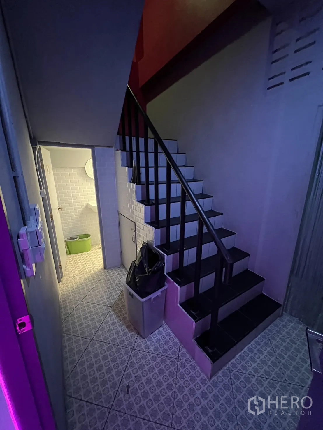 Shophouse for rent or sale in Watthana, Bangkok - Stair landing with patterned floor tiles, stairs and entrance to restroom.
