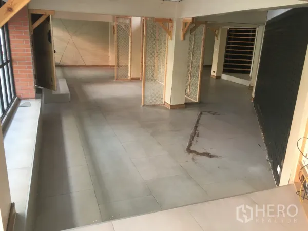 Retail Space for rent in Khlong Toei, Bangkok - Ground-floor retail space with large windows, brick accent wall, and flexible partition screens for layout planning.