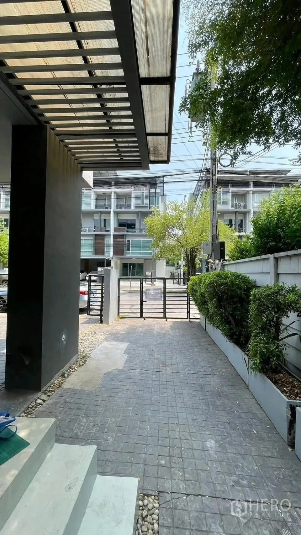 Home Office for rent or sale in Wang Thonglang, Bangkok - Driveway and gate leading to the street with hedges along the side.
