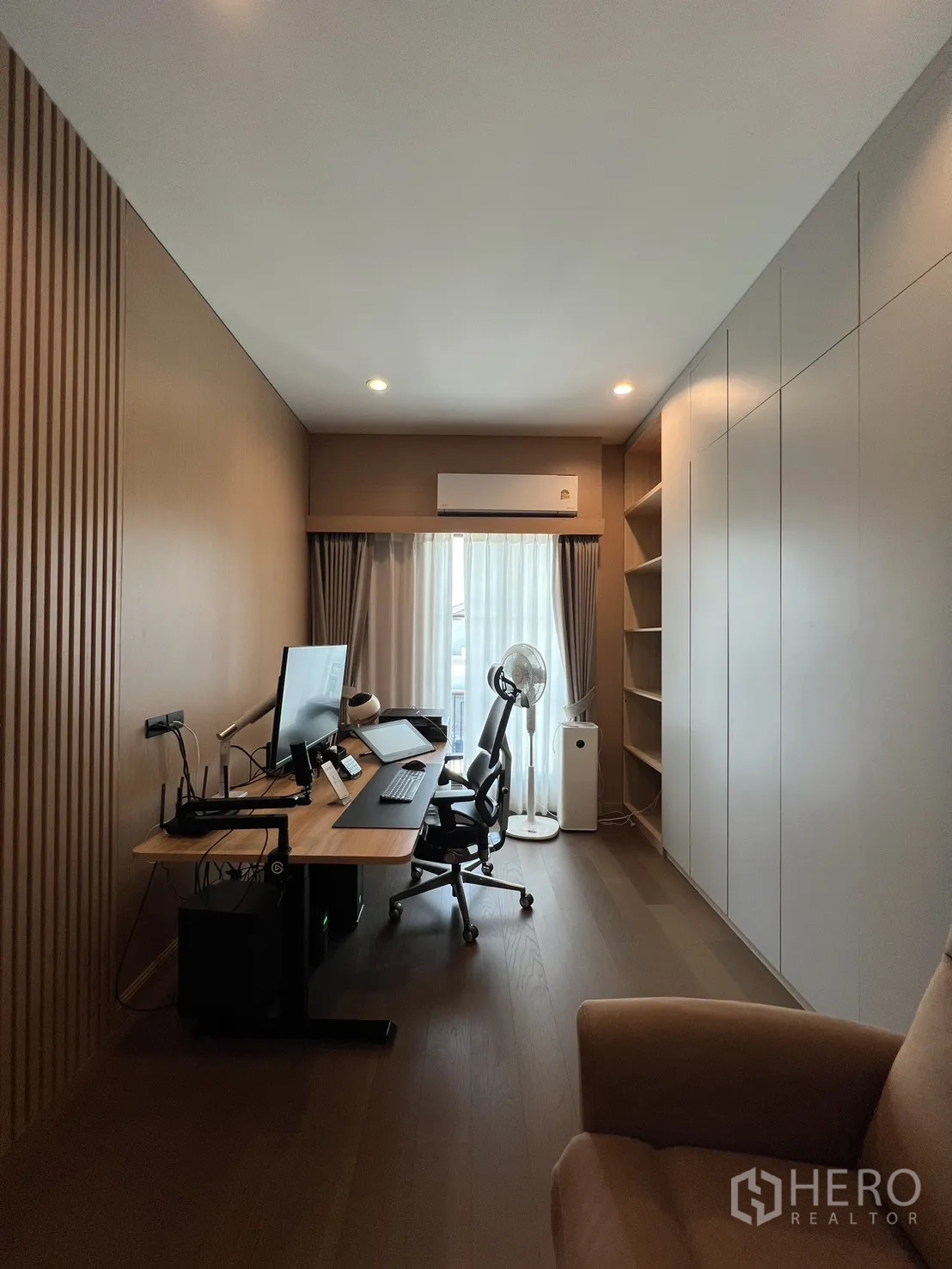 Detached House for rent or sale in Mueang Pathum Thani, Pathum Thani - Fitness room with treadmills, TV wall and large mirror.