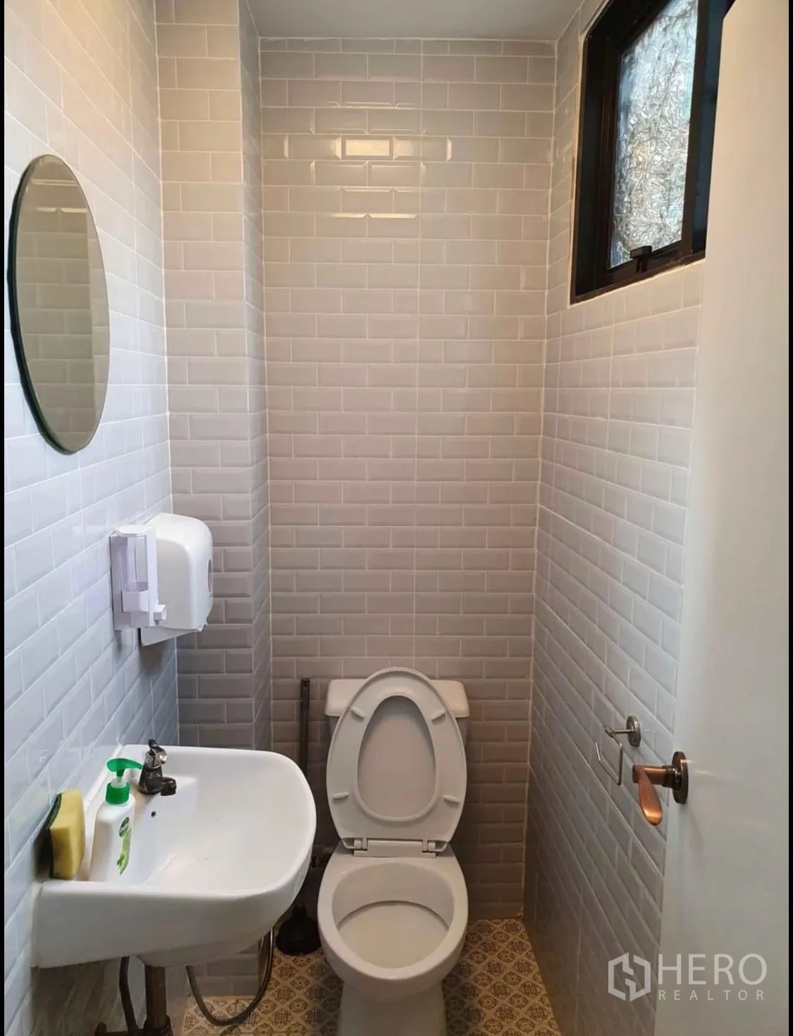 Shophouse for rent or sale in Watthana, Bangkok - Compact restroom with white subway tiles, round mirror and small sink.
