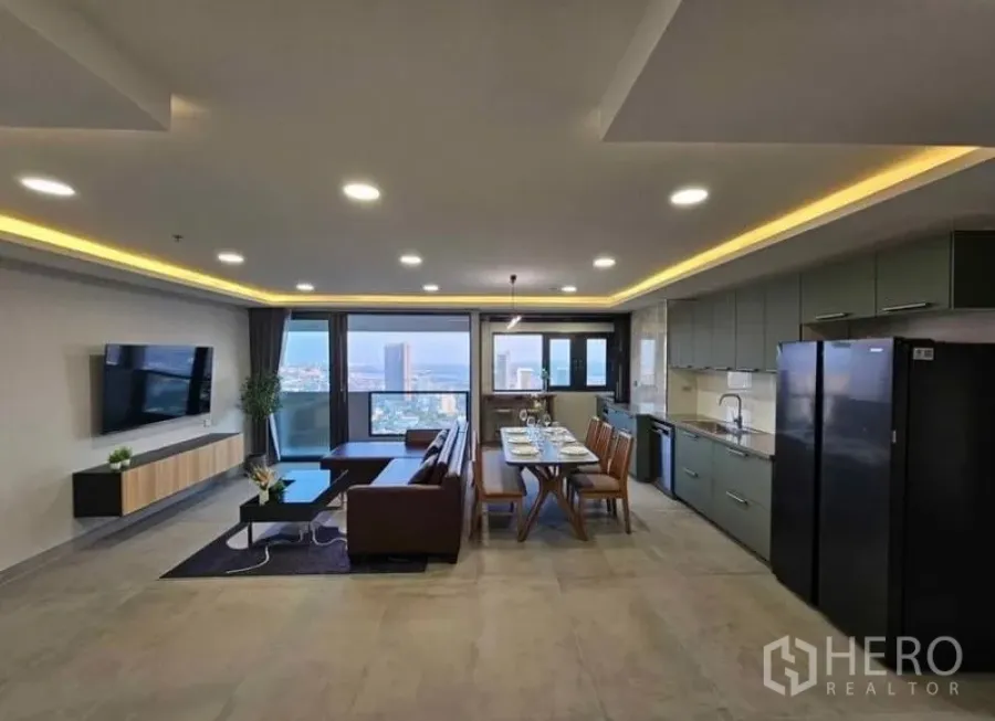 Condominium for rent or sale - Open-plan living and kitchen with recessed lighting and skyline view.