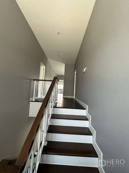 Detached House for sale in Lam Luk Ka, Pathum Thani - Upper corridor and half-landing with dark wood steps.