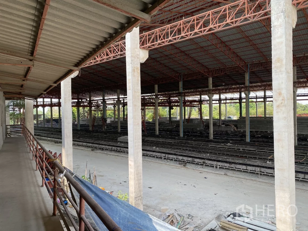 Factory for sale in Chon Buri - Elevated walkway view across the production floor, columns and red truss roofing.