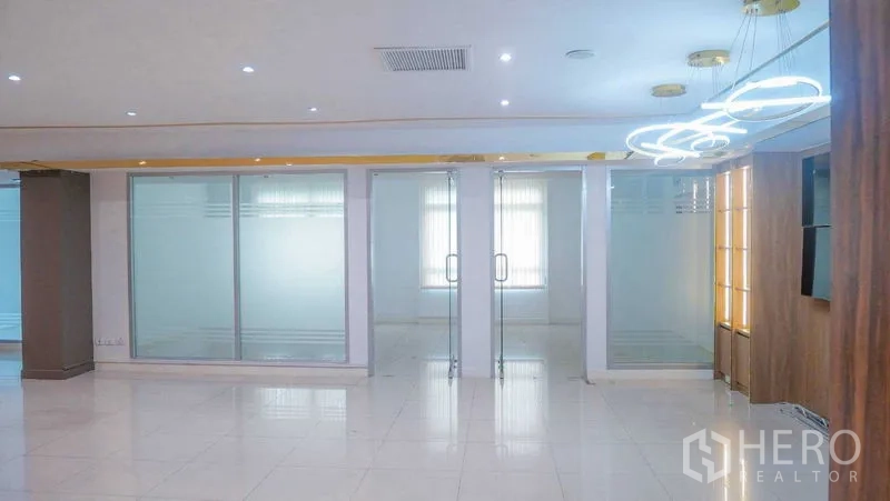 Office Space for rent in Chatuchak, Bangkok - Entrance to meeting rooms with double glass doors, modern circular light fixtures, and white tile floors.
