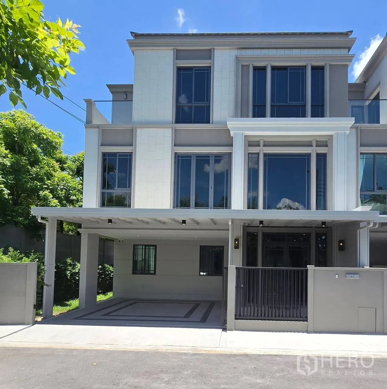 บ้านแฝด for rent in Suan Luang, Bangkok - บ้านแฝดสไตล์ร่วมสมัยสูงสามชั้น พร้อมรั้วหน้าบ้านและที่จอดรถมีหลังคา.