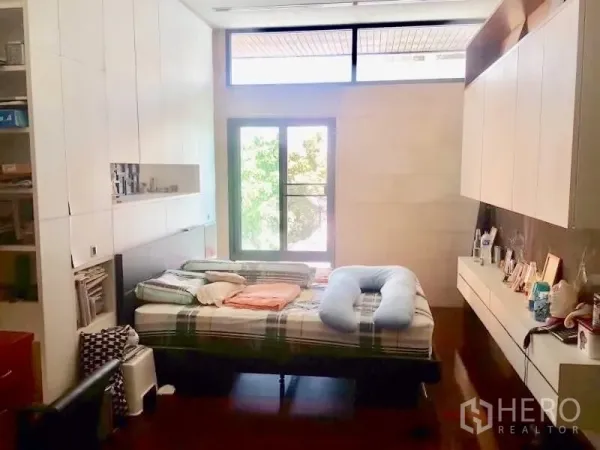 Home Office for rent or sale in Bang Rak, Bangkok - Master bedroom with built-in cabinetry, large window and warm wood floors.