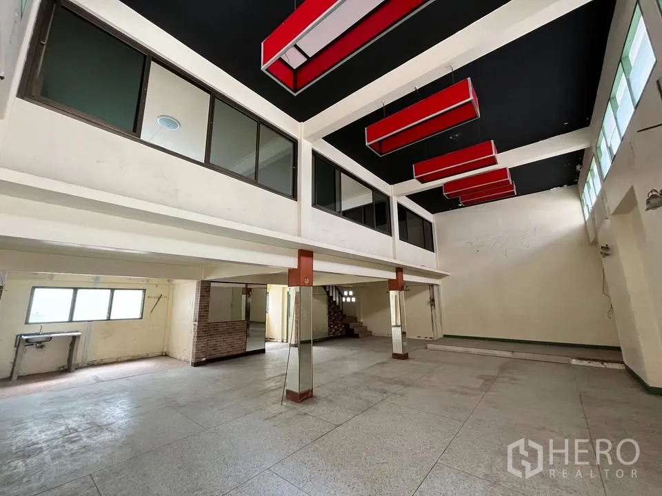 Detached House for rent in Suan Luang, Bangkok - Double-height open hall with mezzanine windows and red ceiling light boxes.