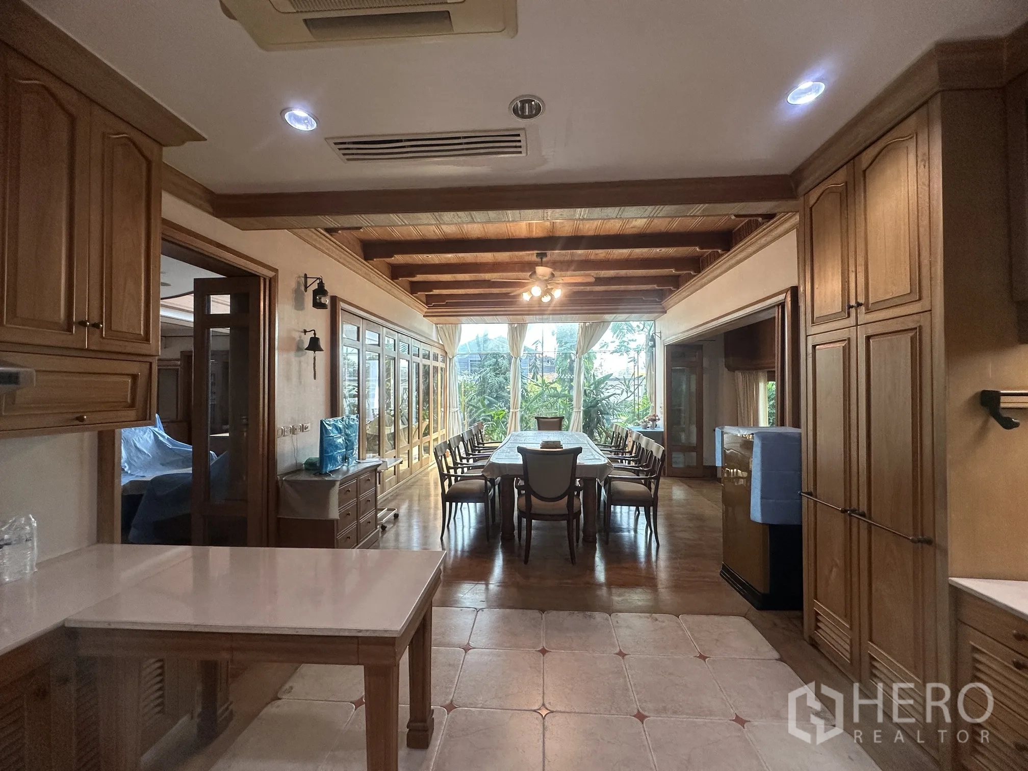 Detached House for rent in Lam Luk Ka, Pathum Thani - Open kitchen corridor leading to a long dining area with wood cabinetry.