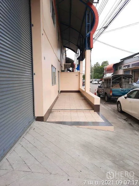 工厂 出租在Bang Bua Thong, Nonthaburi - 街侧带顶棚的瓷砖装卸平台，紧邻卷帘门。
