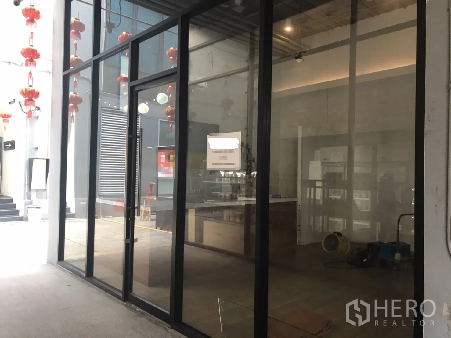 Retail Space for rent in Khlong Toei, Bangkok - Glass-front shop with full-height windows and entrance door facing a covered walkway.