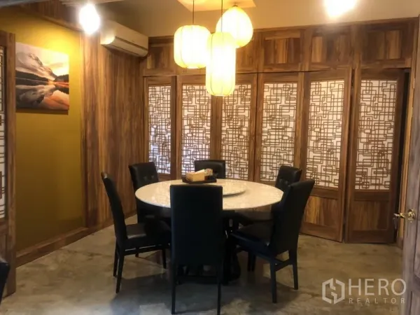 Shophouse for rent in Watthana, Bangkok - Warm wood private room with decorative lattice panels, round table and soft pendant lights.