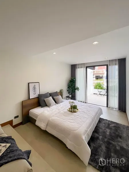 Townhouse for rent in Khlong Toei, Bangkok - Bright bedroom with sliding doors opening to a private balcony.