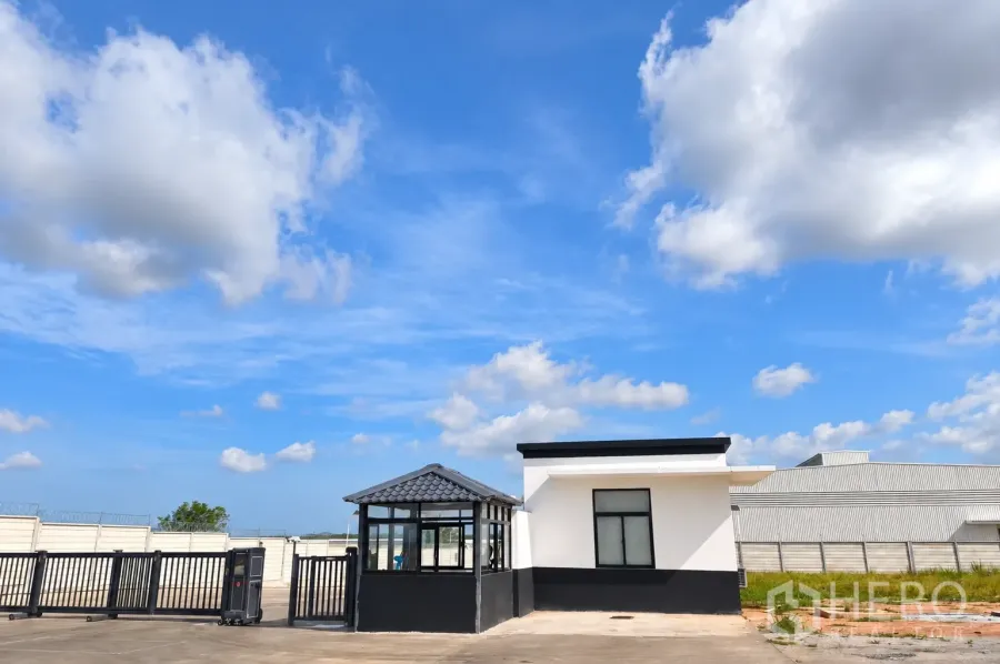 仓库 for rent in Si Racha, Chon Buri - 仓库出入口设有保安岗亭、滑动大门与围墙。