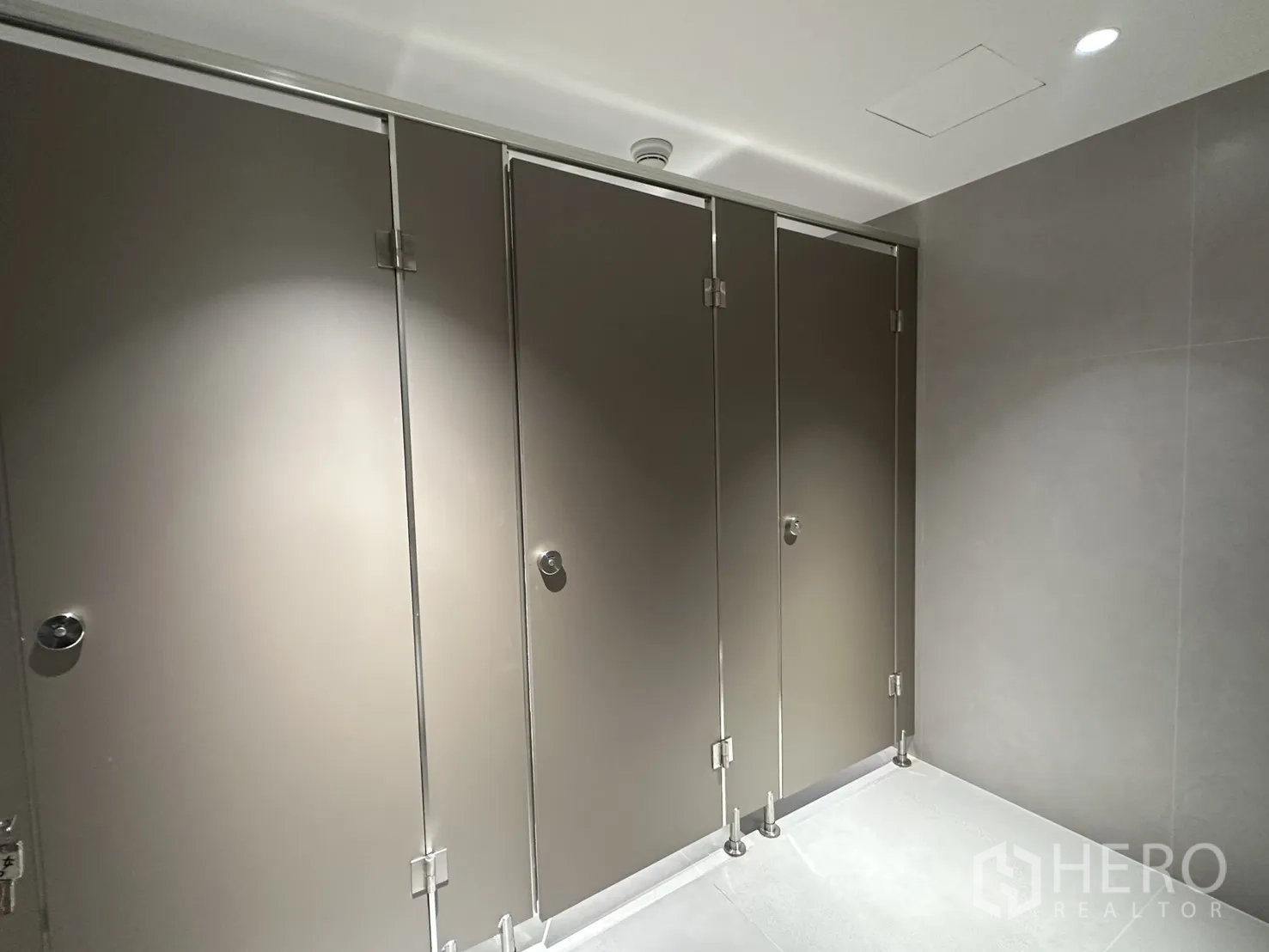 Office Space for rent in Din Daeng, Bangkok - Row of gray toilet stalls in a clean office restroom.